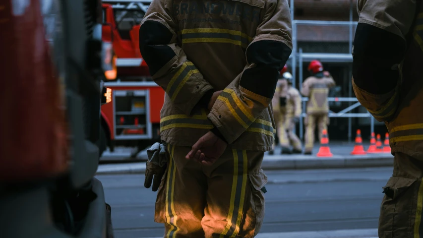 firemen wearing protective gear standing in the street