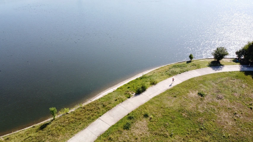 the man is riding his bike down the pathway by the water