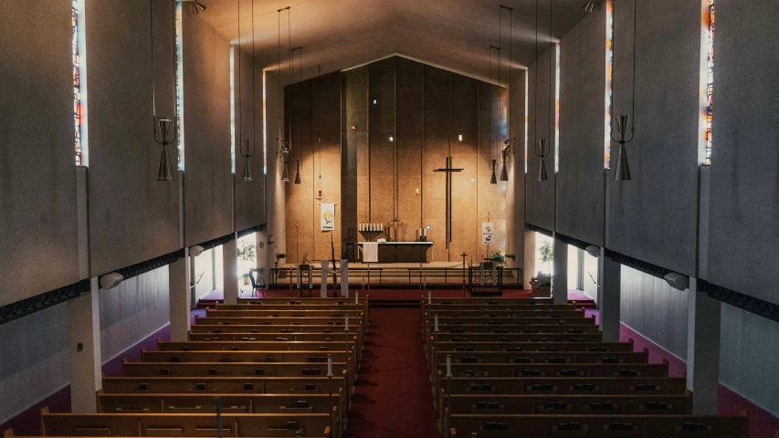 an empty church with pews and a wall with decorative decorations