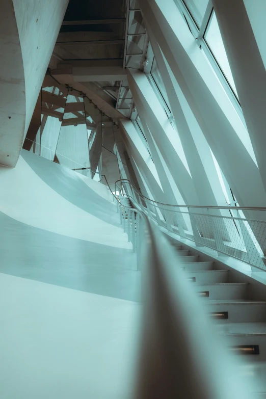 a spiral stairway with metal railings underneath a skylight