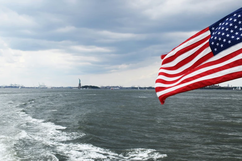 an american flag flies from the back of a boat