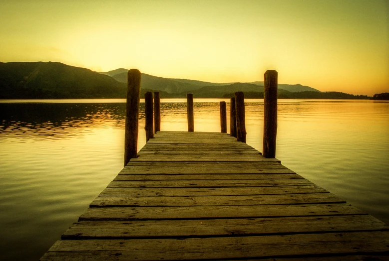 a dock on the water during a sunset