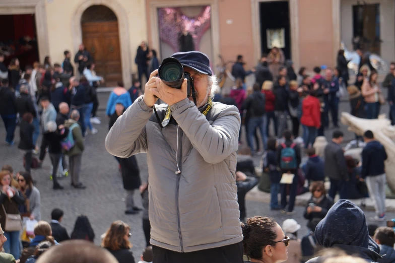 a pographer uses a lens to capture a large crowd in the city