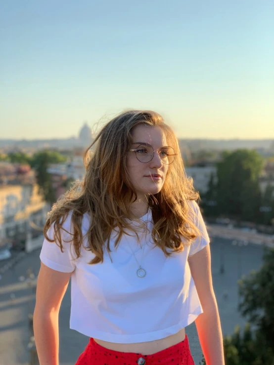 a young woman is posing for the camera on a bridge