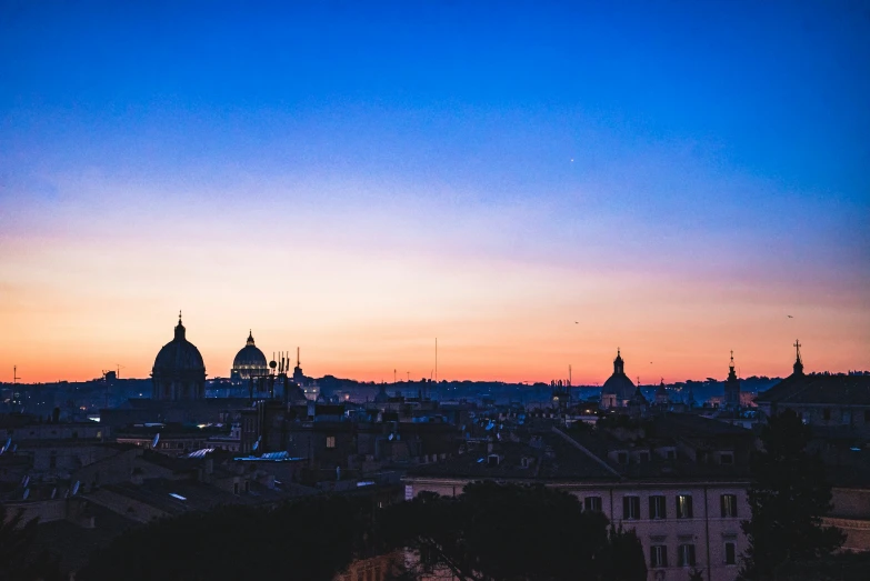 the city of paris with silhouettes of buildings and a sunset