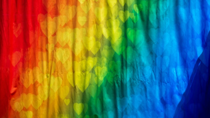 a rainbow - colored curtain hanging in front of a white wall