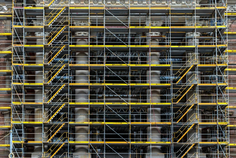 a fire hydrant covered in yellow scaffolding and pipes