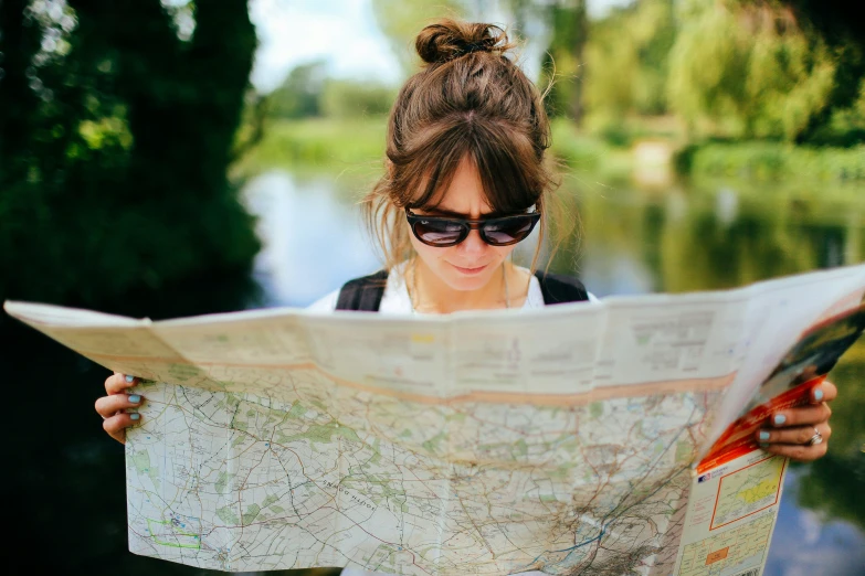 a woman is looking at a map and pointing to it