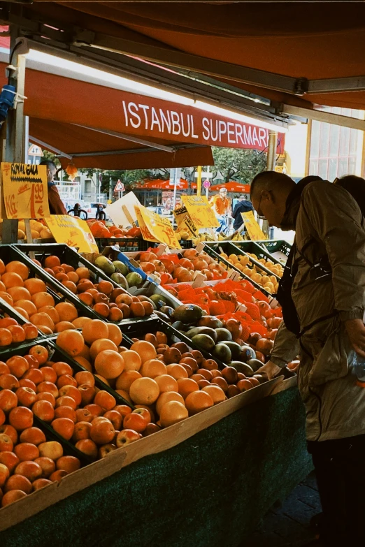 a couple of people looking at produce on display