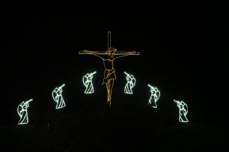 christmas lights depicting jesus on the cross at night