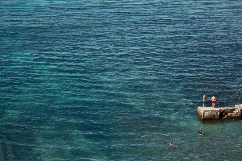 some men standing on a dock in the middle of the ocean