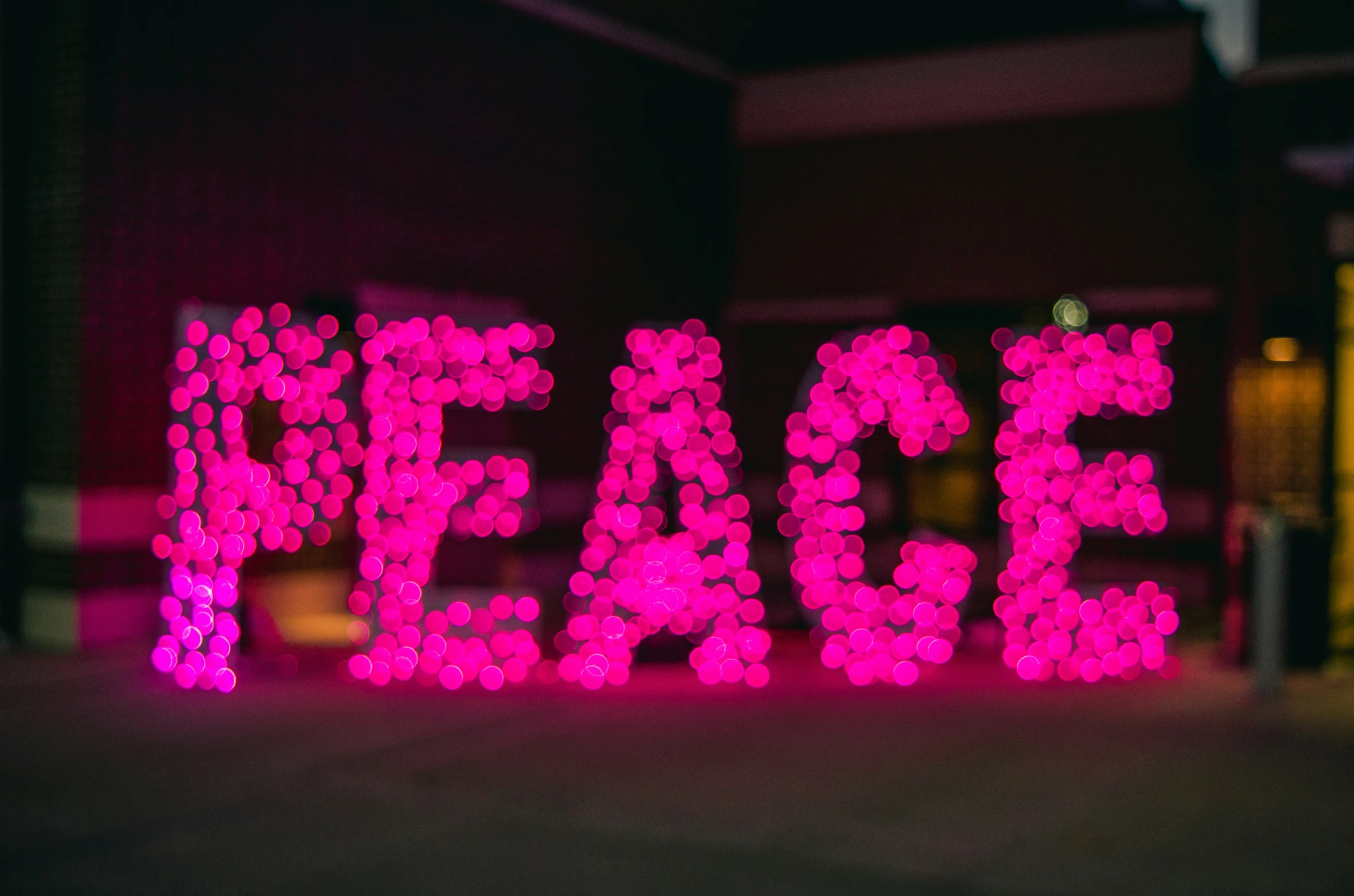 there is a colorful sign that says peace and lights up in the background