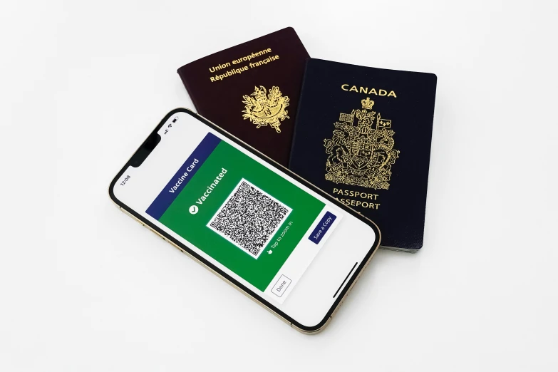 an iphone next to a british passport and a smartphone