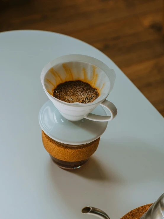 a white saucer next to a coffee cup on top of a white table