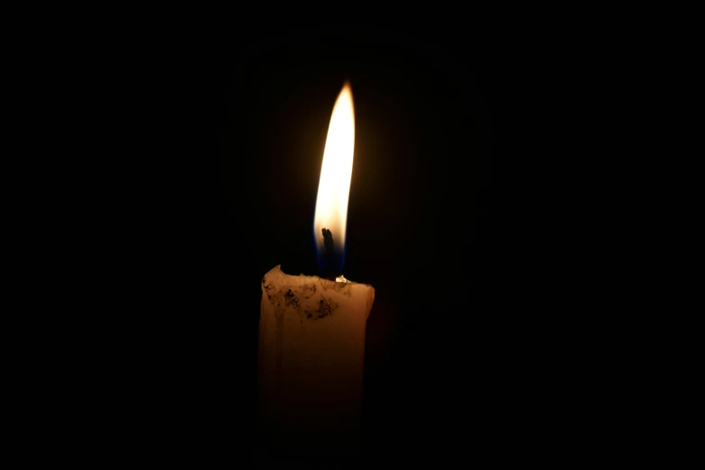 a candle with one glowing white flame and black background