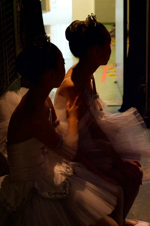 two girls in dress sitting on a bench