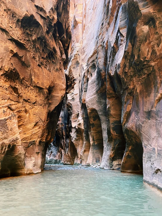 a person standing in a narrow canyon surrounded by water