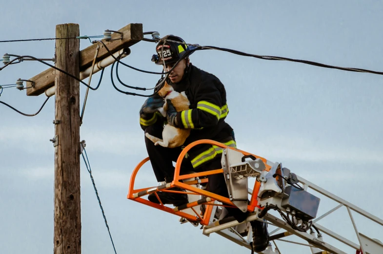 a man standing on top of an electric pole while holding an electrical device