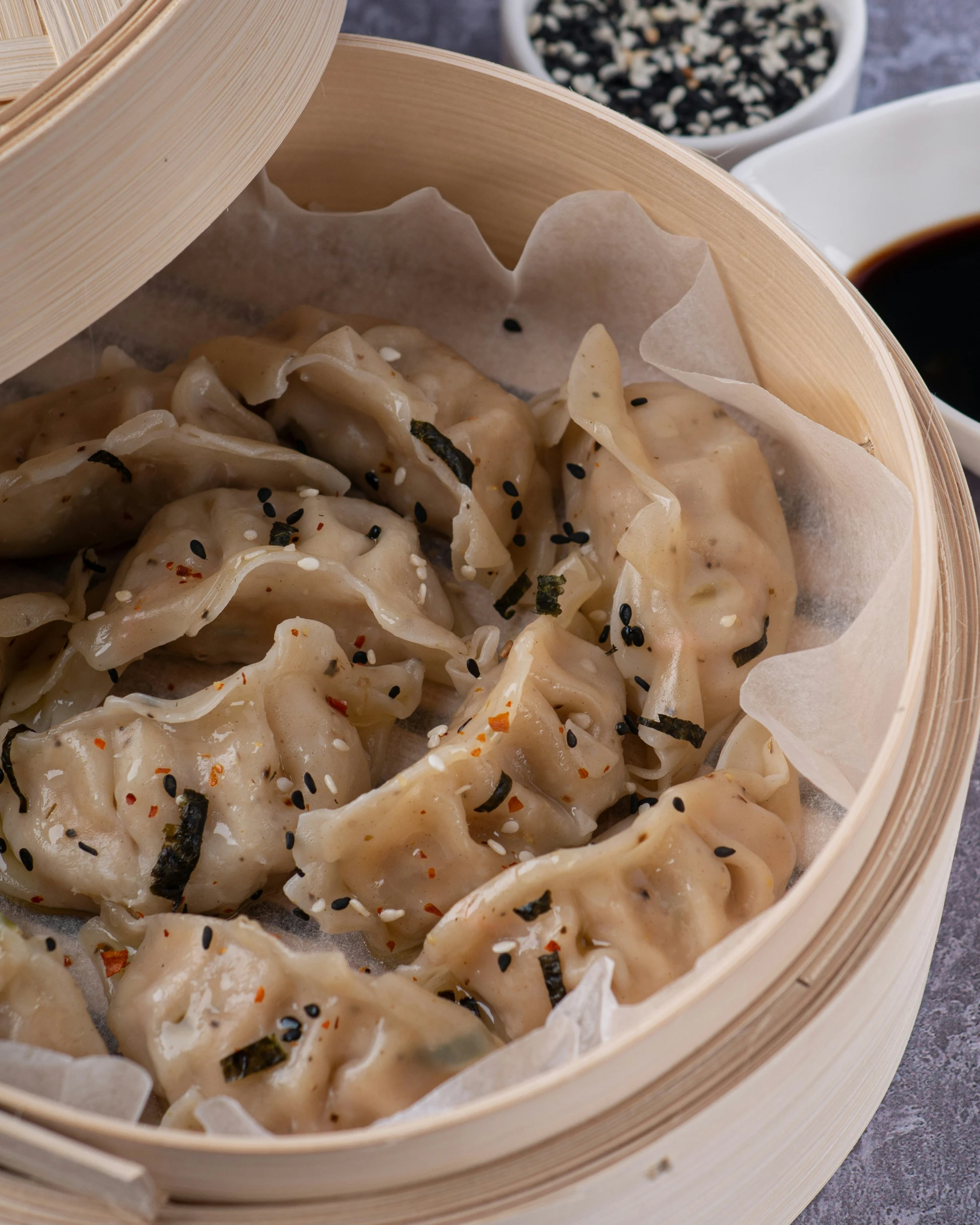 a wooden container with dumplings and black sesame seeds