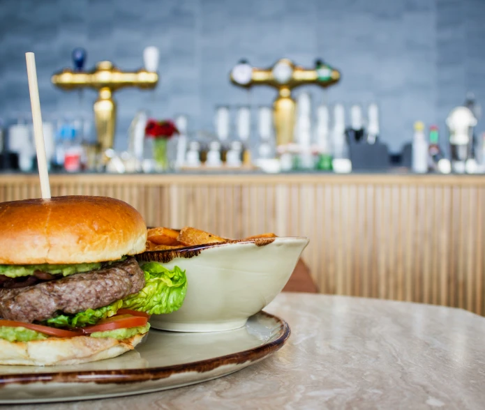 a cheeseburger and fries served on an old plate