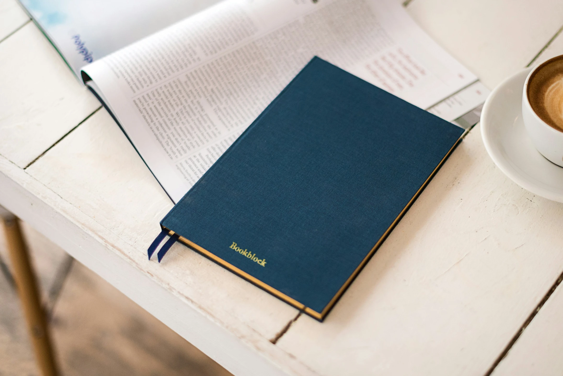 a blue book sitting next to a cup of coffee