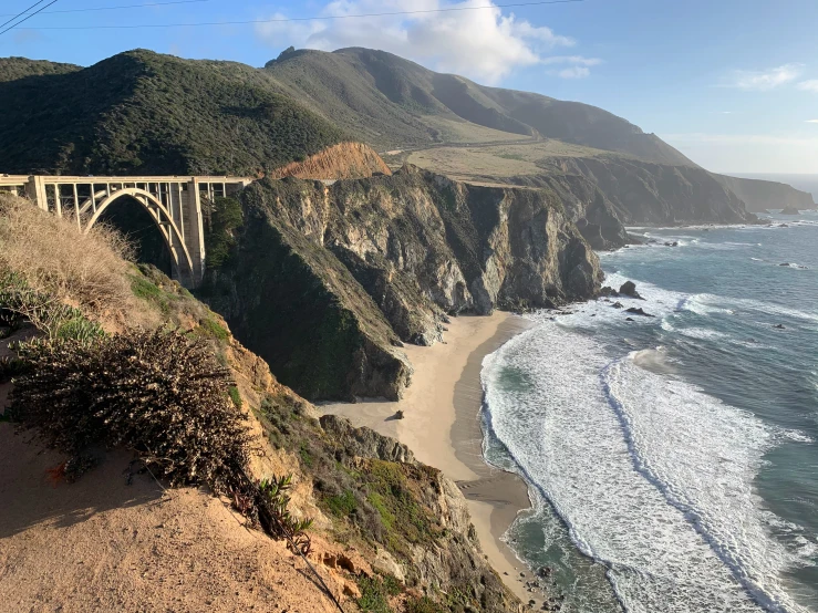 a scenic view of a rocky coastline and a bridge