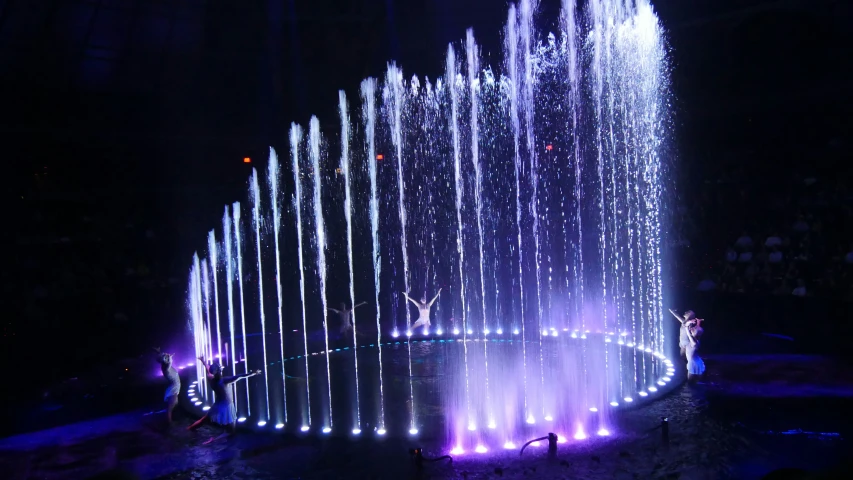 a colorful fountain is surrounded by lights in a circular formation