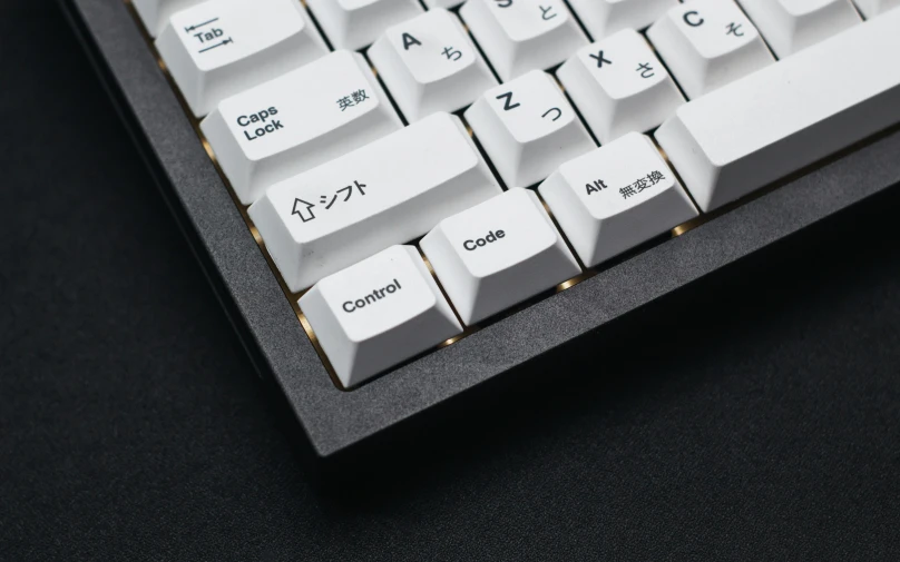 an apple computer key board on a black surface