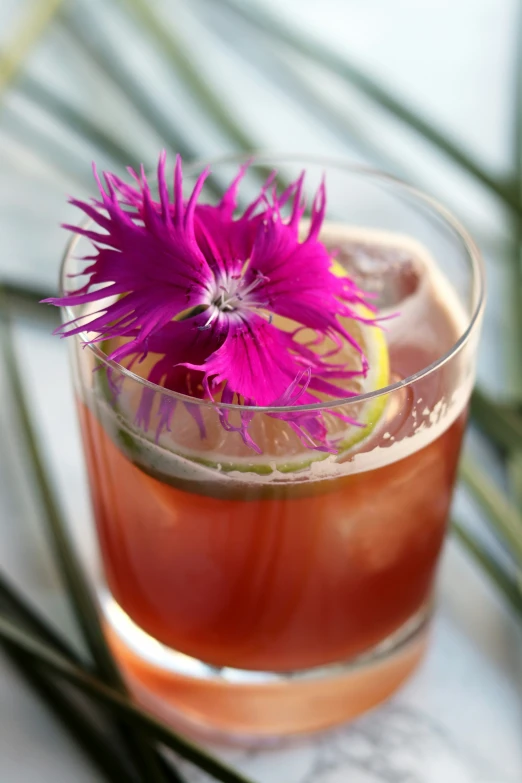 there is a purple flower on the top of a glass