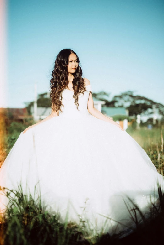 a woman in a wedding dress standing outdoors