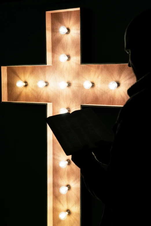 a large cross with lots of light bulbs shining on it