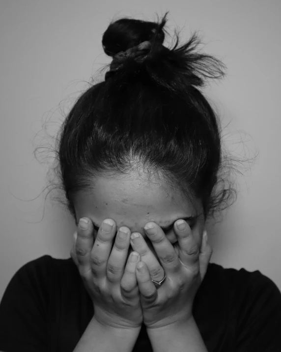 a woman with her hands covering her face