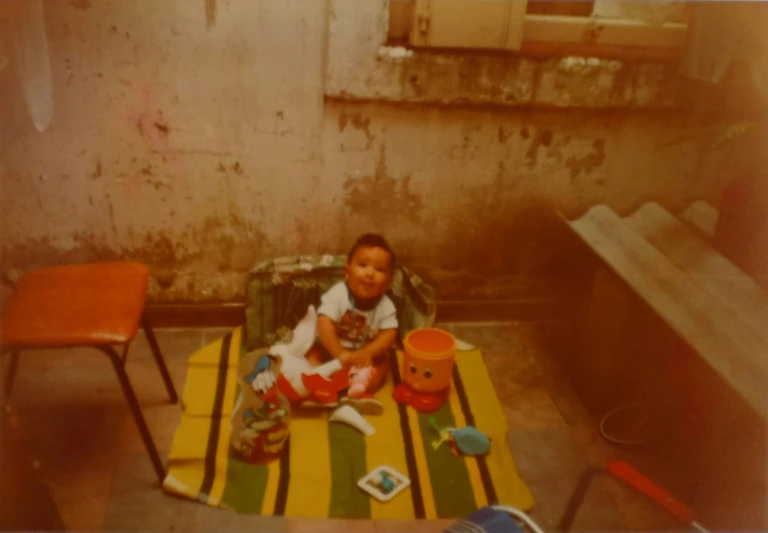 a small child sits on a chair with a cup and bowl