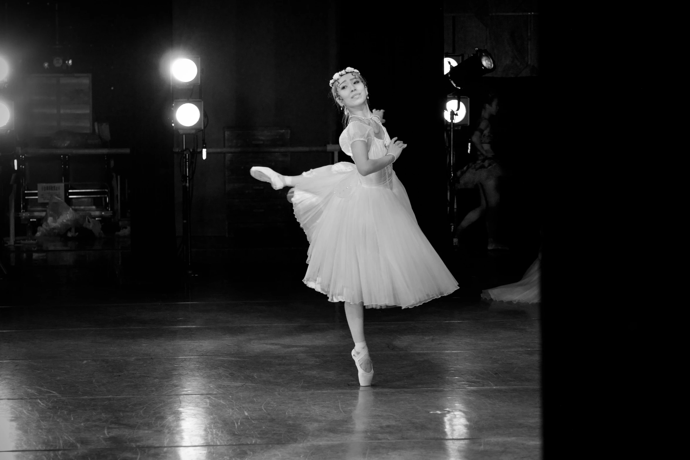 a woman is posing on the stage in a white dress