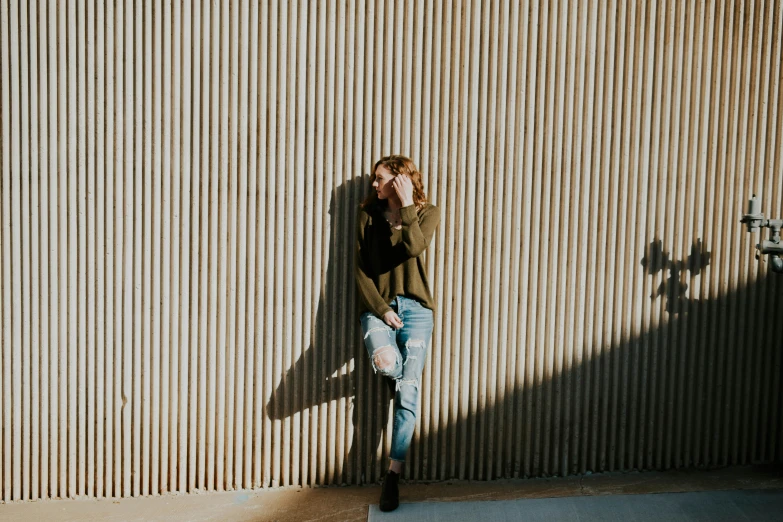 a woman is leaning up against a wall