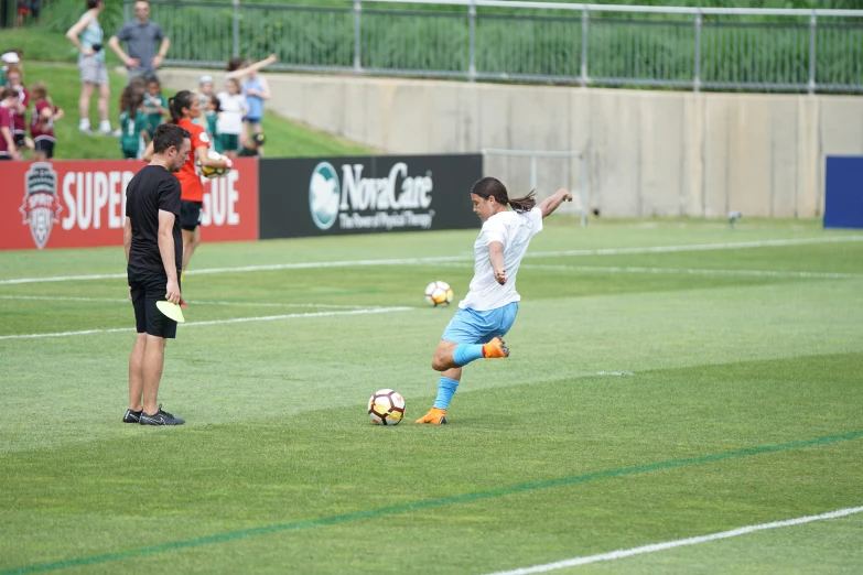 a couple of guys play soccer while people watch