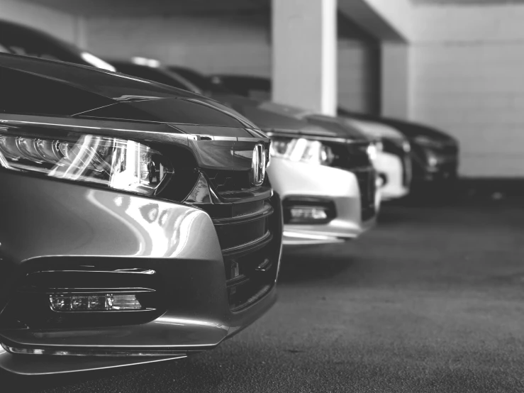 the rear end of some cars parked in a garage