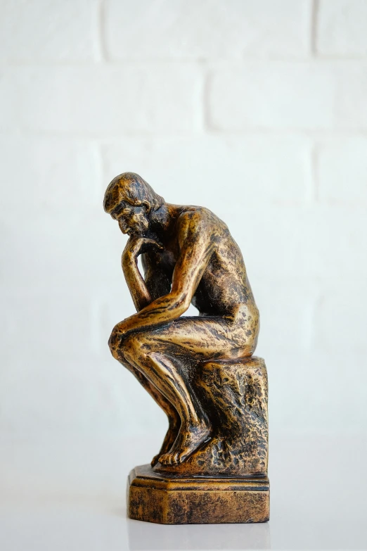 a statue of a man kneeling on a marble base