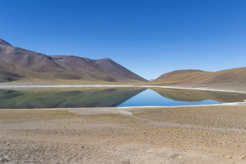 water surrounded by mountains on an island in the desert