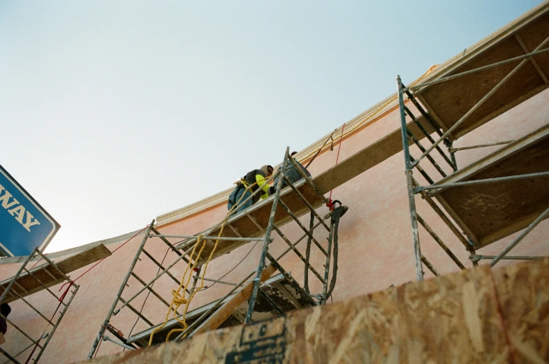 a construction site with workers and a blue sign on the wall