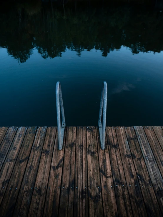 the two metal poles are connected to the wooden dock