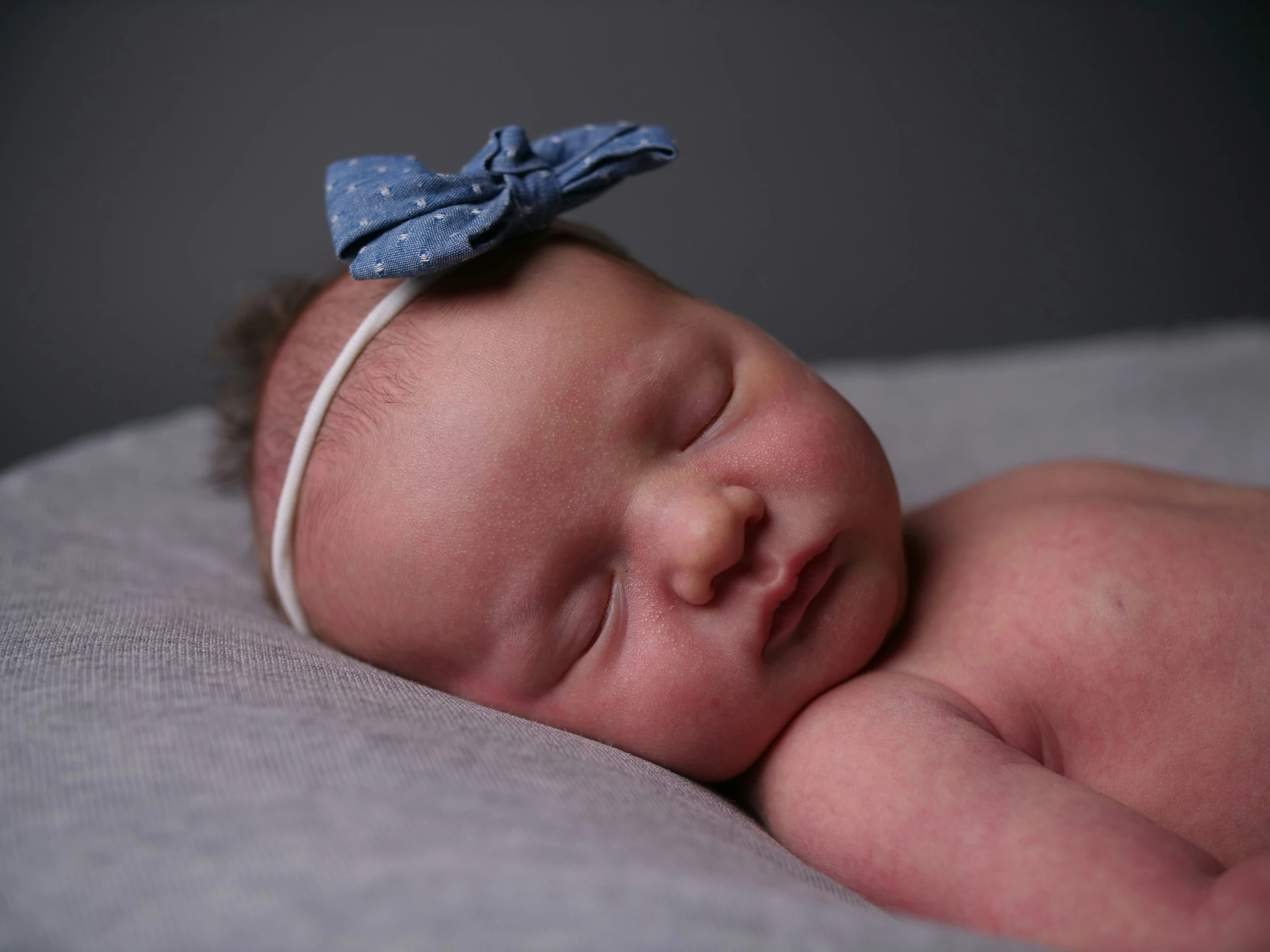 a baby boy wrapped in a blue bow sleeping