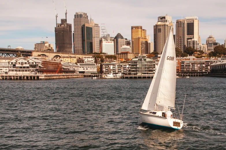 a sailboat with a skyline of other buildings