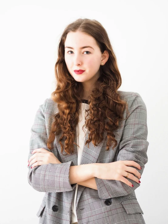 an attractive woman with curly hair wearing a suit