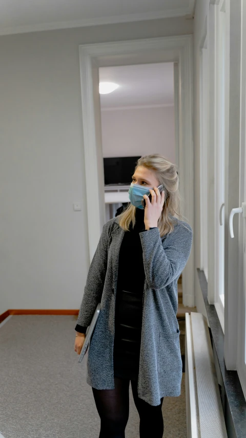 a person standing in a hallway on a cellphone