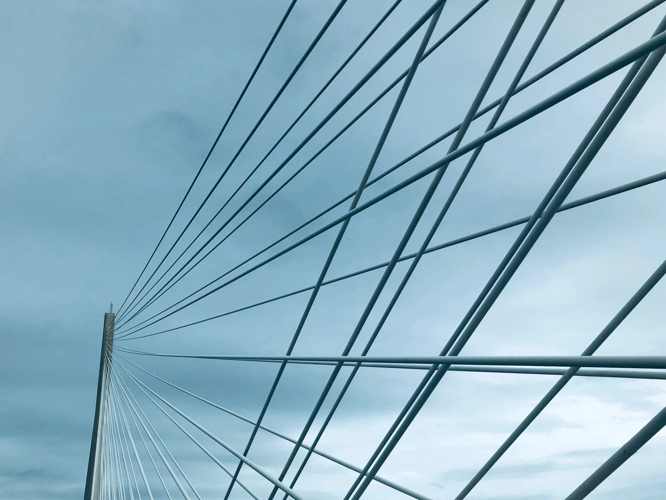 a bridge's diagonal lines against a gray sky