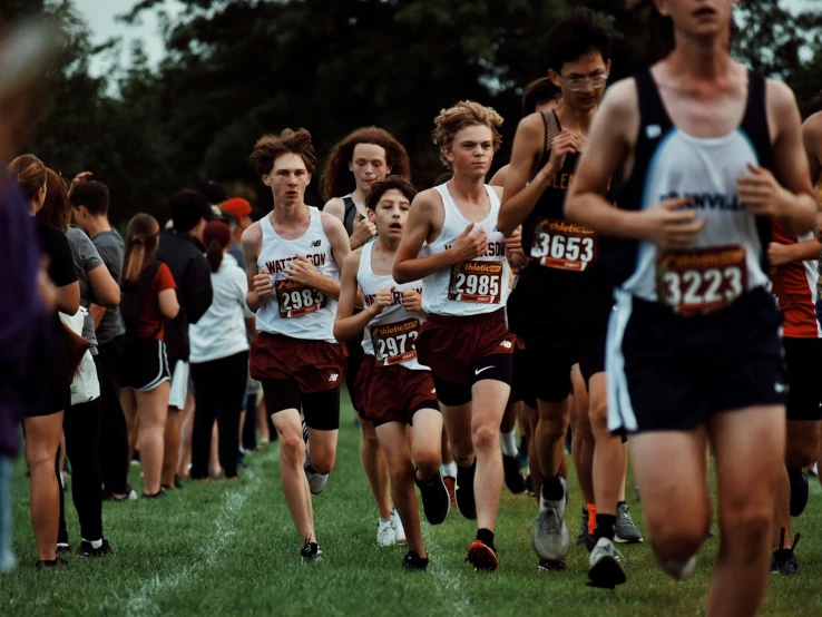 group of people wearing shorts and holding umbrellas running in a line