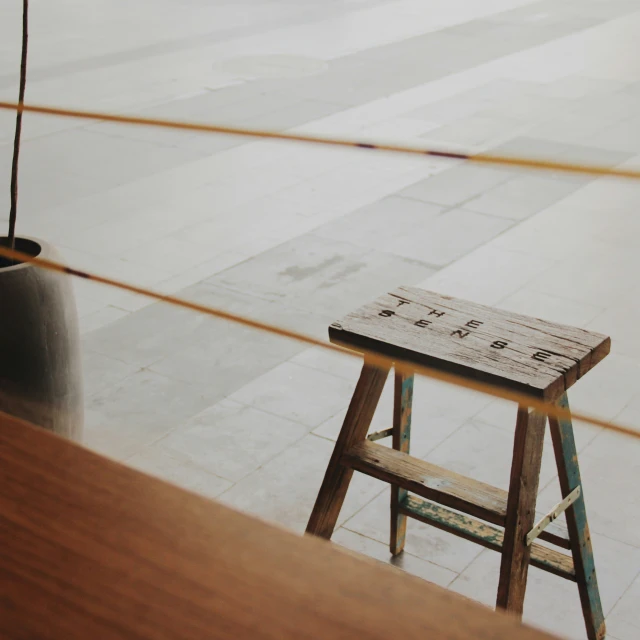 the wood chair is sitting by the large black pot