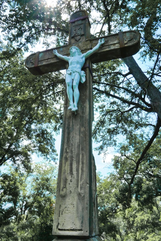 a statue of jesus hangs on the side of the cross