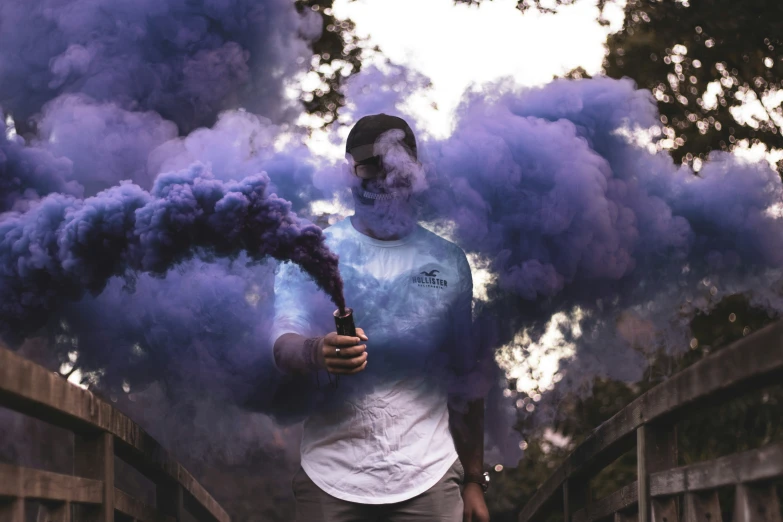 a man is smoking purple and white smoke